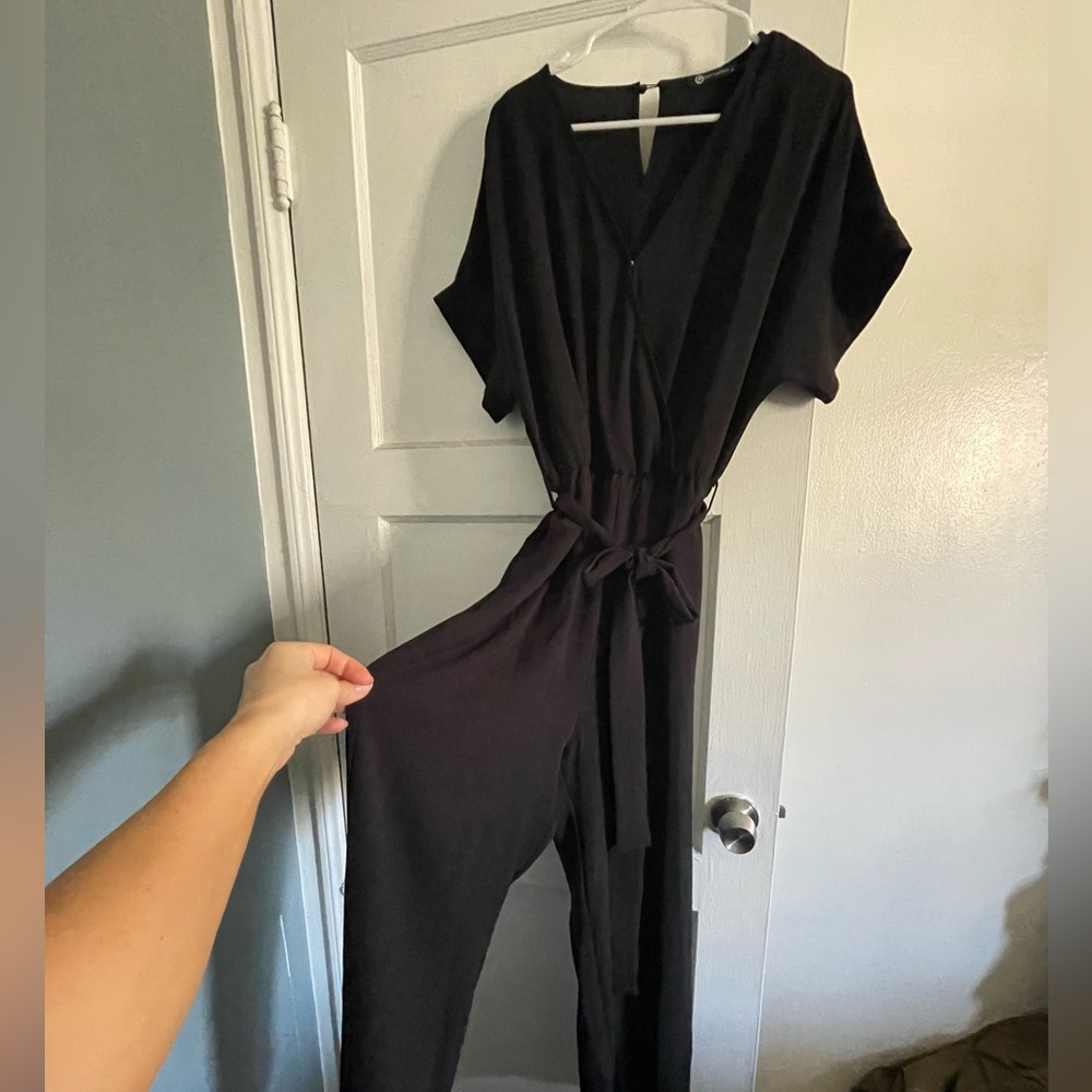 Black jumpsuit with snap front and tie at the waist. Size medium.